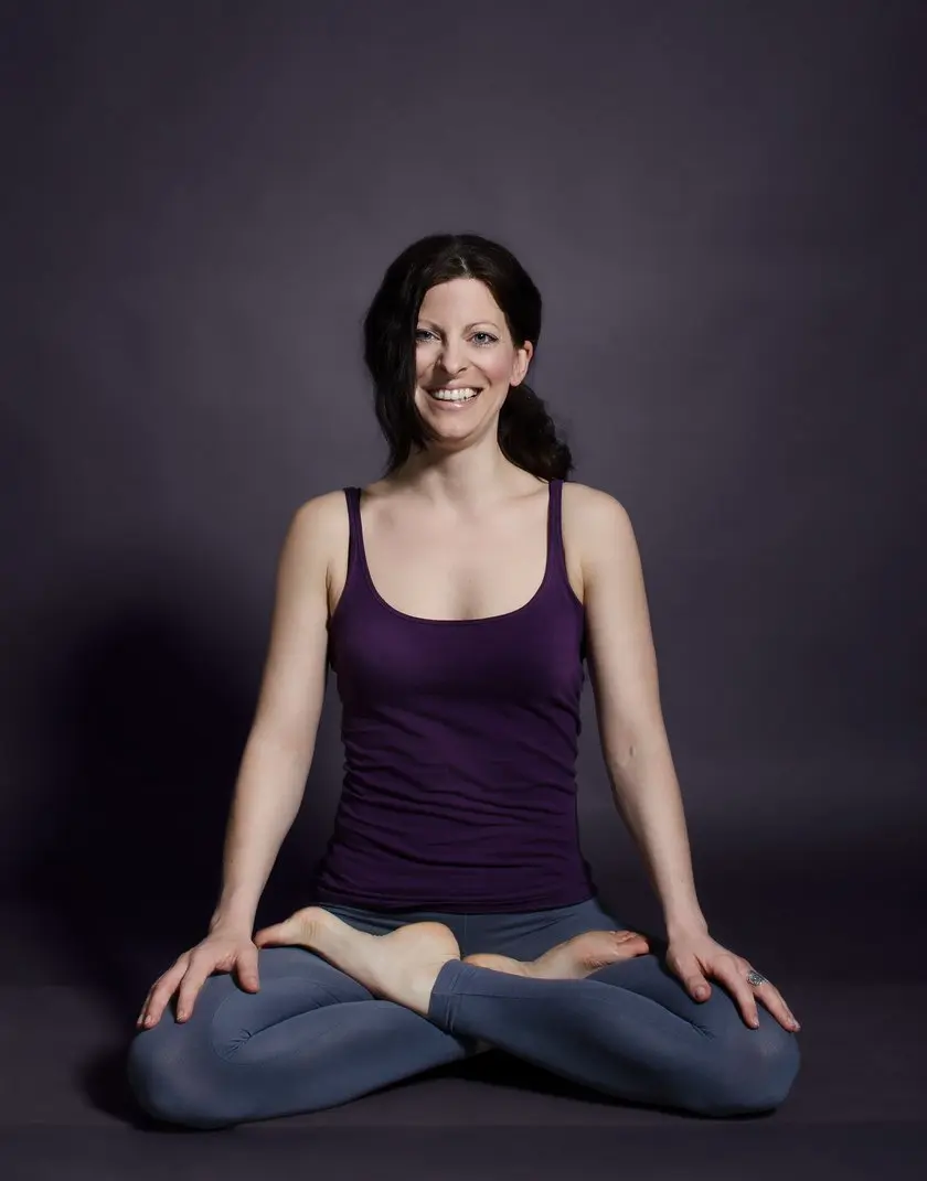 Anke sitzt entspannt und lächelnd im Yogasitz